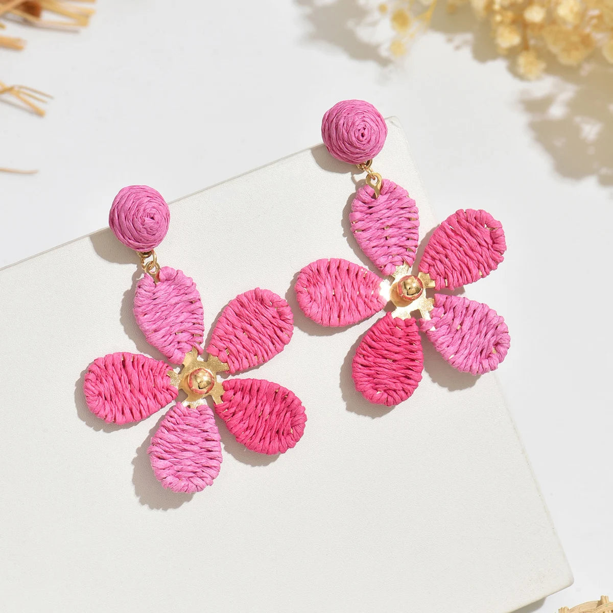 Bohemian-style hand-woven raffia flower earrings—a unique, minimalist design perfect for everyday wear.