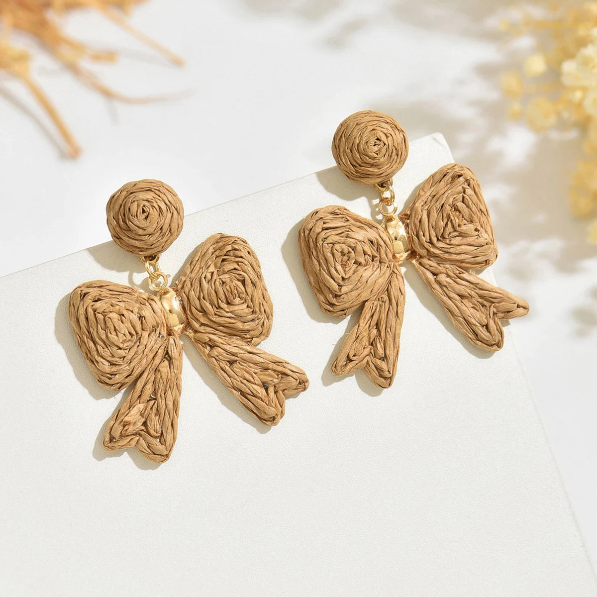 Handcrafted Bohemian-style raffia bow earrings, perfect for women to wear on vacation or for any occasion. They also make a wond