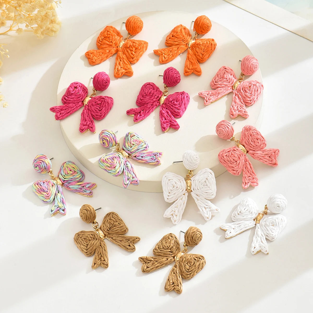 Handcrafted Bohemian-style raffia bow earrings, perfect for women to wear on vacation or for any occasion. They also make a wond