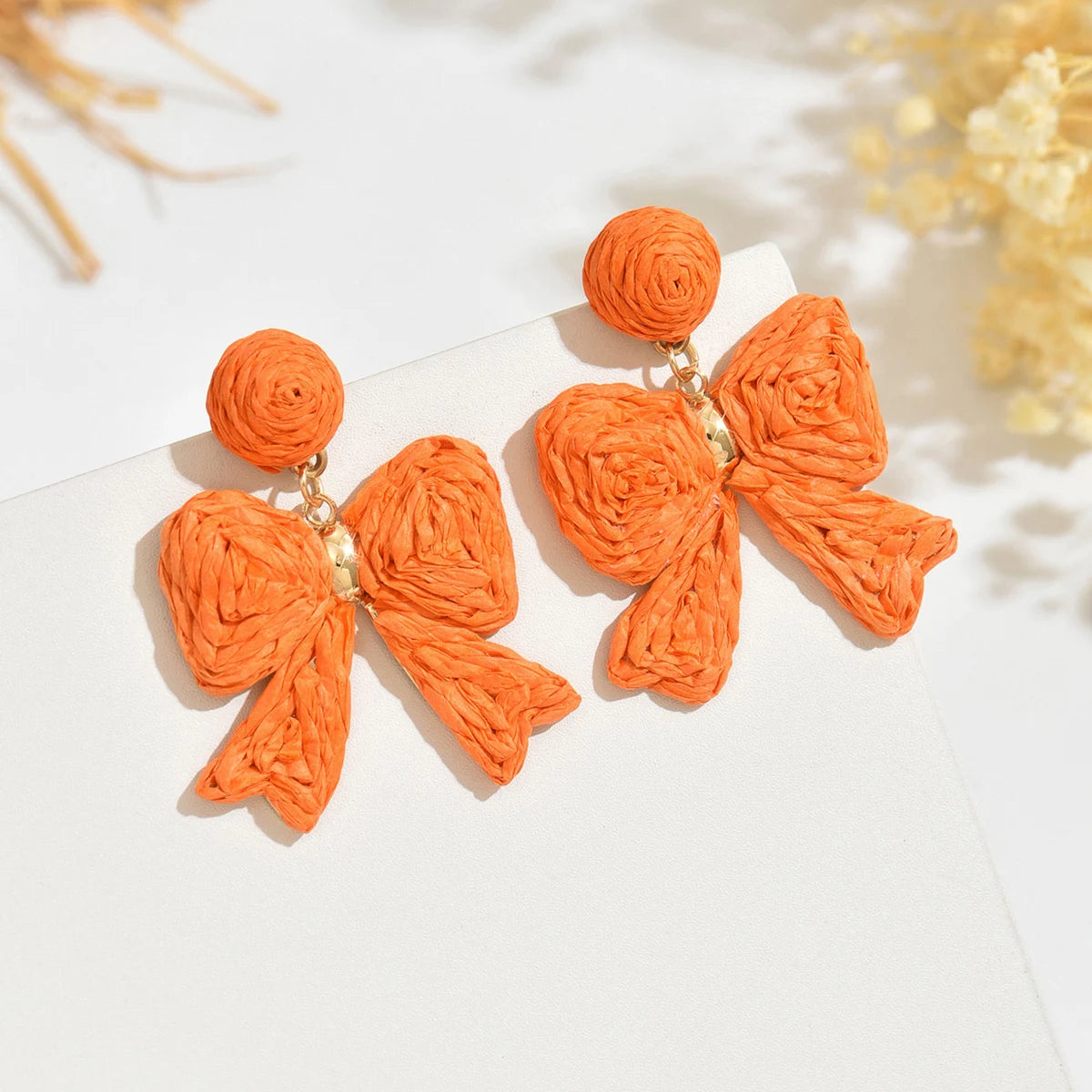 Handcrafted Bohemian-style raffia bow earrings, perfect for women to wear on vacation or for any occasion. They also make a wond