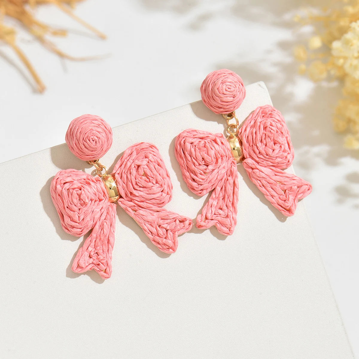 Handcrafted Bohemian-style raffia bow earrings, perfect for women to wear on vacation or for any occasion. They also make a wond