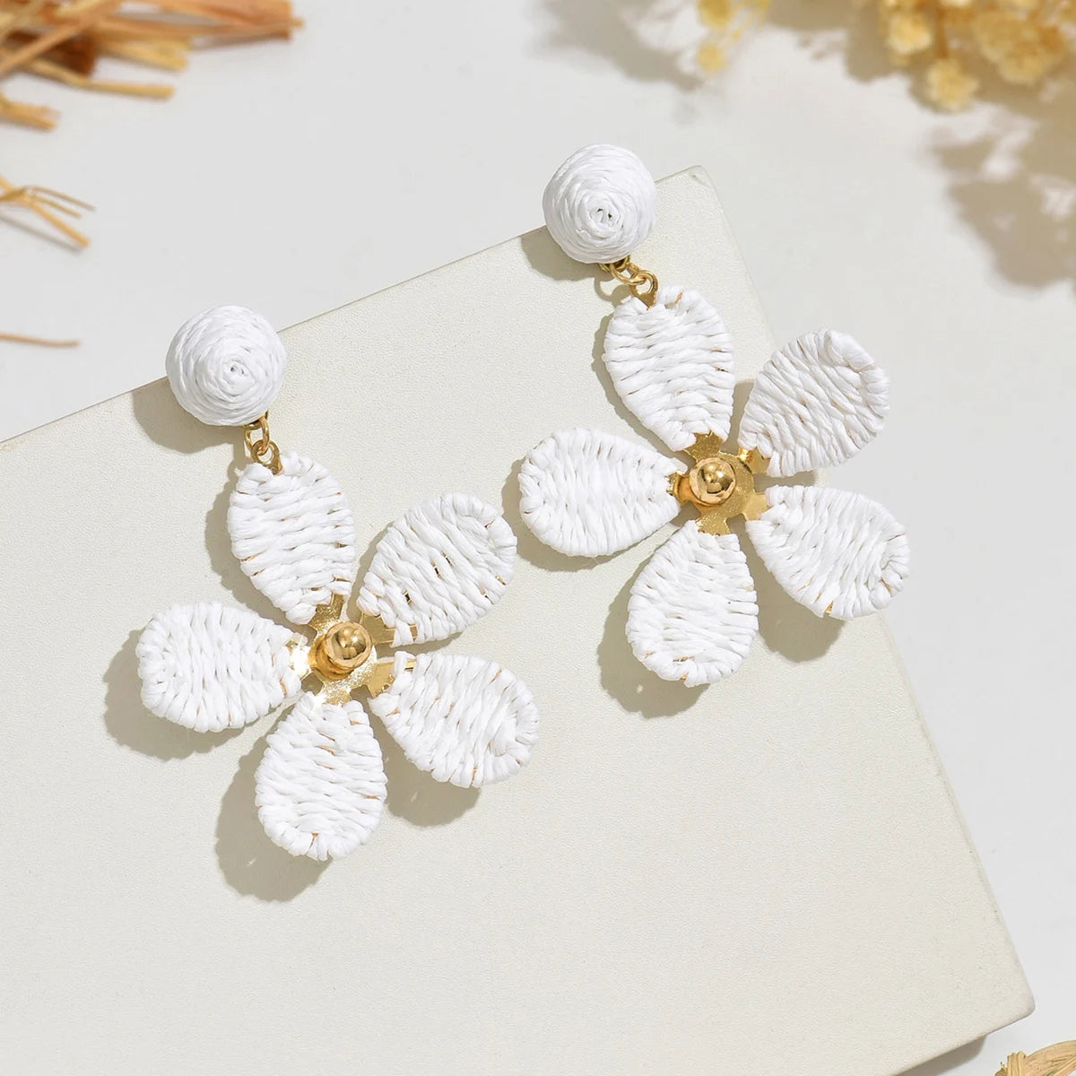 Bohemian-style hand-woven raffia flower earrings—a unique, minimalist design perfect for everyday wear.
