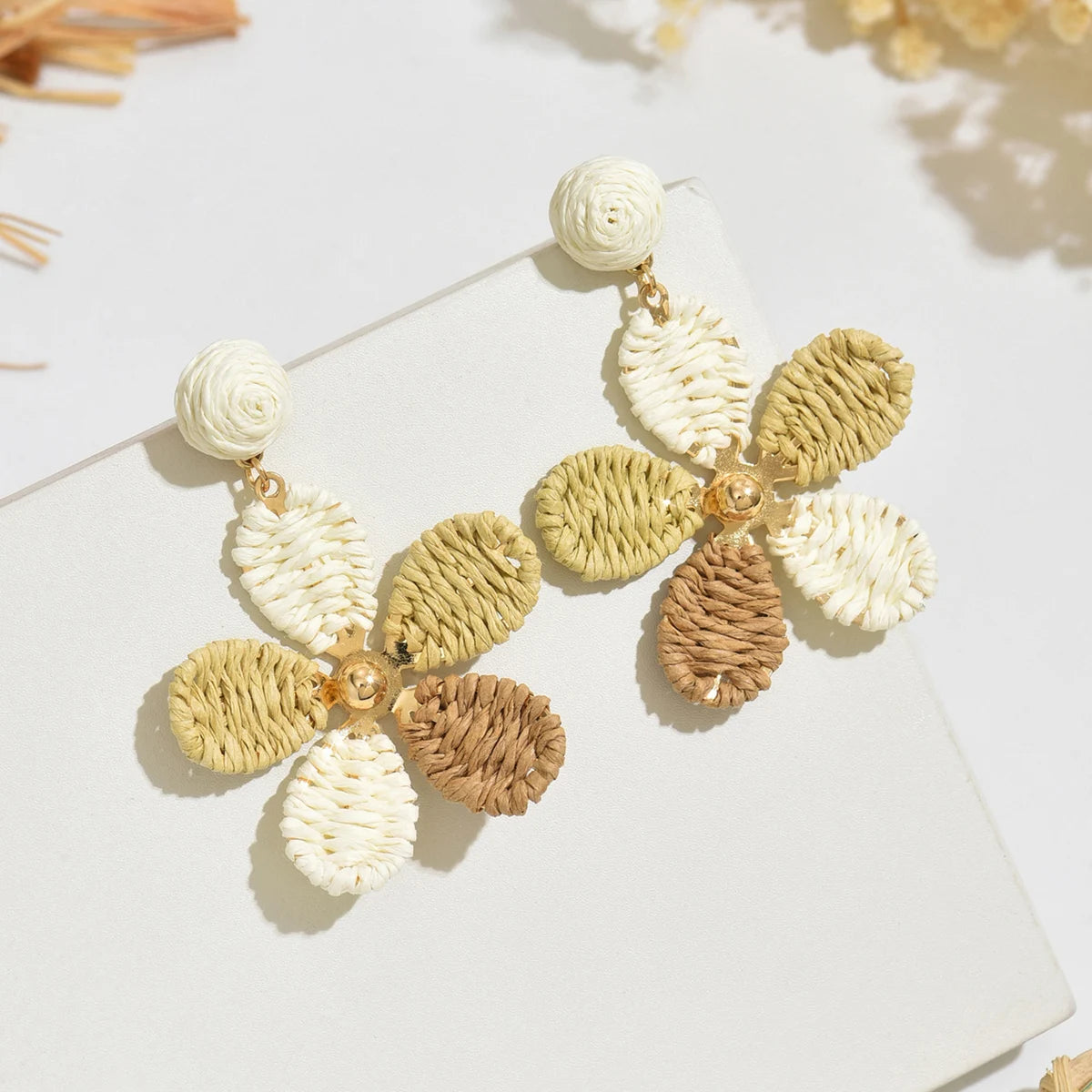 Bohemian-style hand-woven raffia flower earrings—a unique, minimalist design perfect for everyday wear.