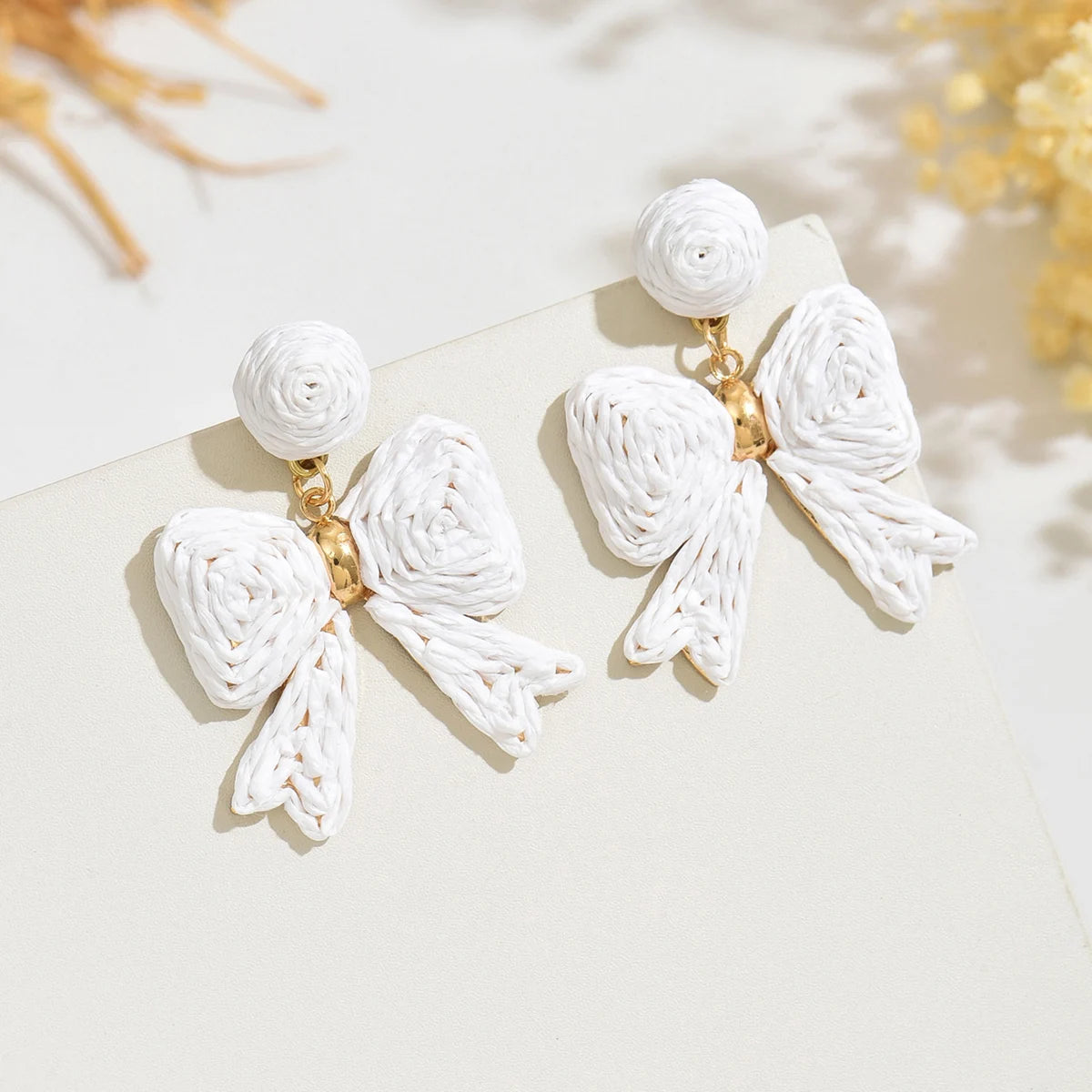 Handcrafted Bohemian-style raffia bow earrings, perfect for women to wear on vacation or for any occasion. They also make a wond