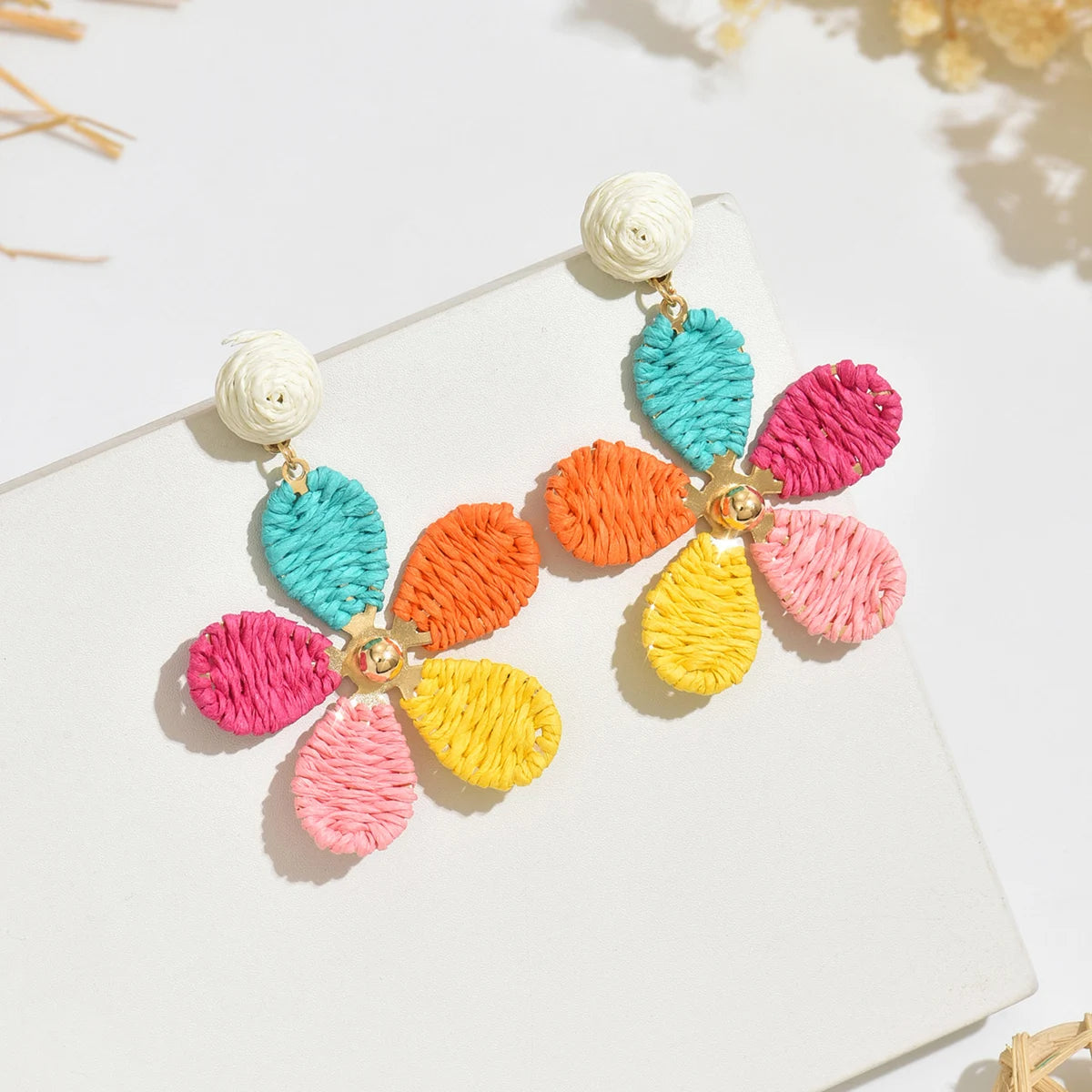 Bohemian-style hand-woven raffia flower earrings—a unique, minimalist design perfect for everyday wear.
