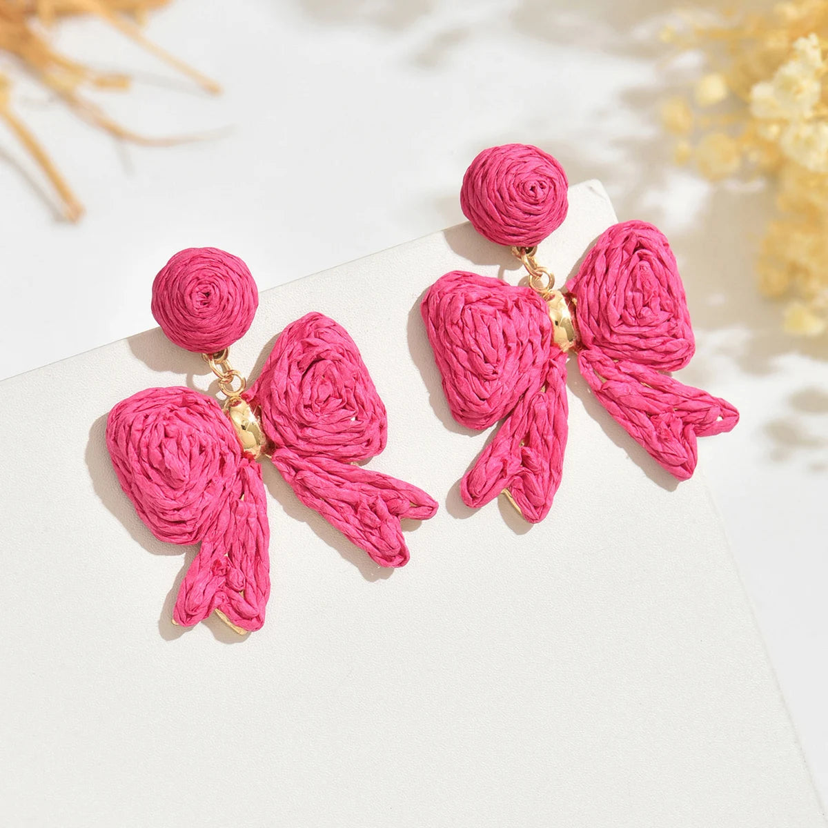 Handcrafted Bohemian-style raffia bow earrings, perfect for women to wear on vacation or for any occasion. They also make a wond