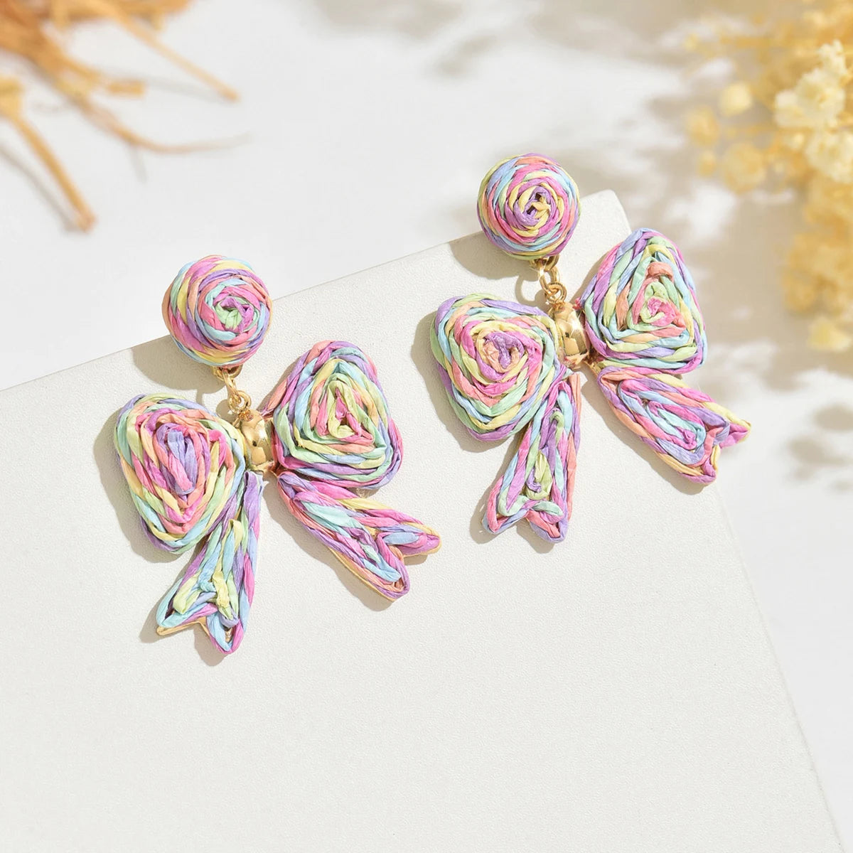 Handcrafted Bohemian-style raffia bow earrings, perfect for women to wear on vacation or for any occasion. They also make a wond
